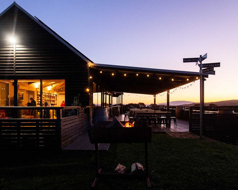 Outdoor setting at Bangor Vineyard Shed with a fire pit at dusk.