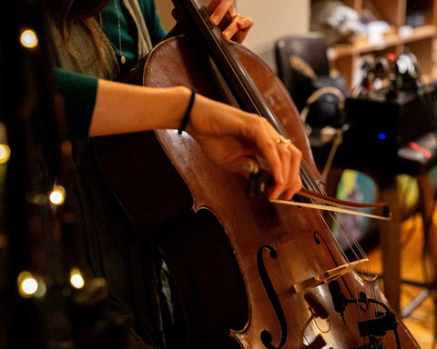 Musician playing a cello with blurred background at Bangor Vineyard Shed