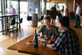 A couple dining indoors at Bangor restaurant. Bar and barrel seating can be seen in the background. Book a table online at Bangor Restaurant.