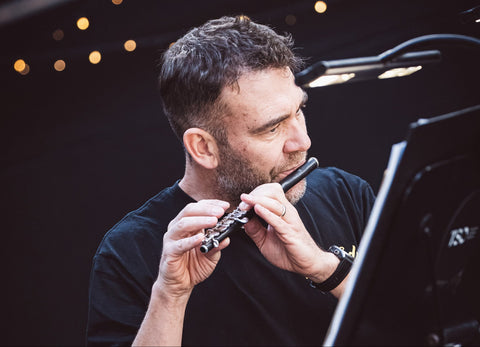 Lloyd Hudson from the Tasmanian Symphony Orchestra playing a piccolo with a dark background